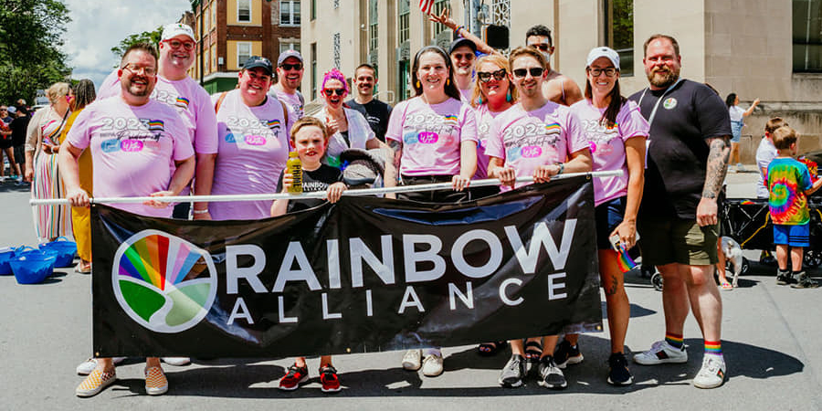 Rainbow Alliance group photo behind a banner